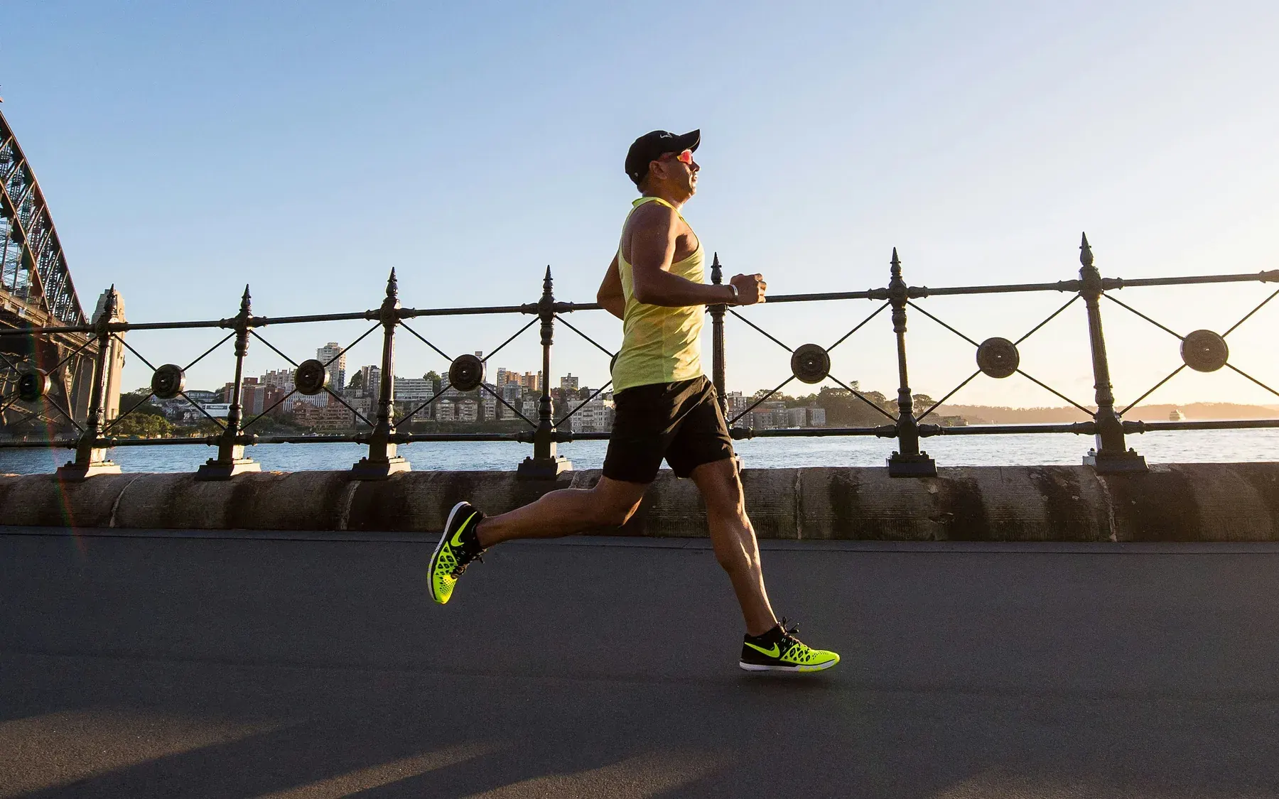 Un hombre corre junto al agua a primera hora de la mañana